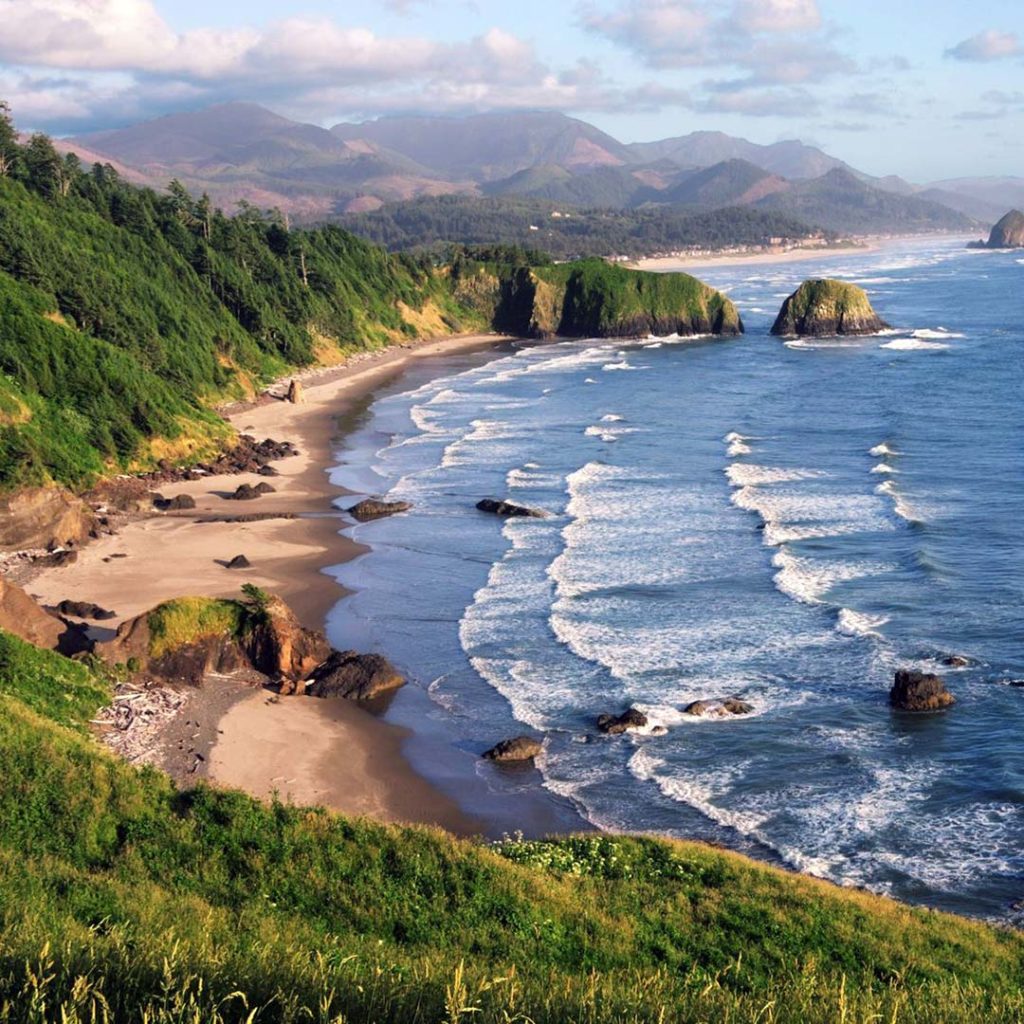 View of waves rolling to shore beneath the viewpoint at Ecola State Park near Cannon Beach Oregon.